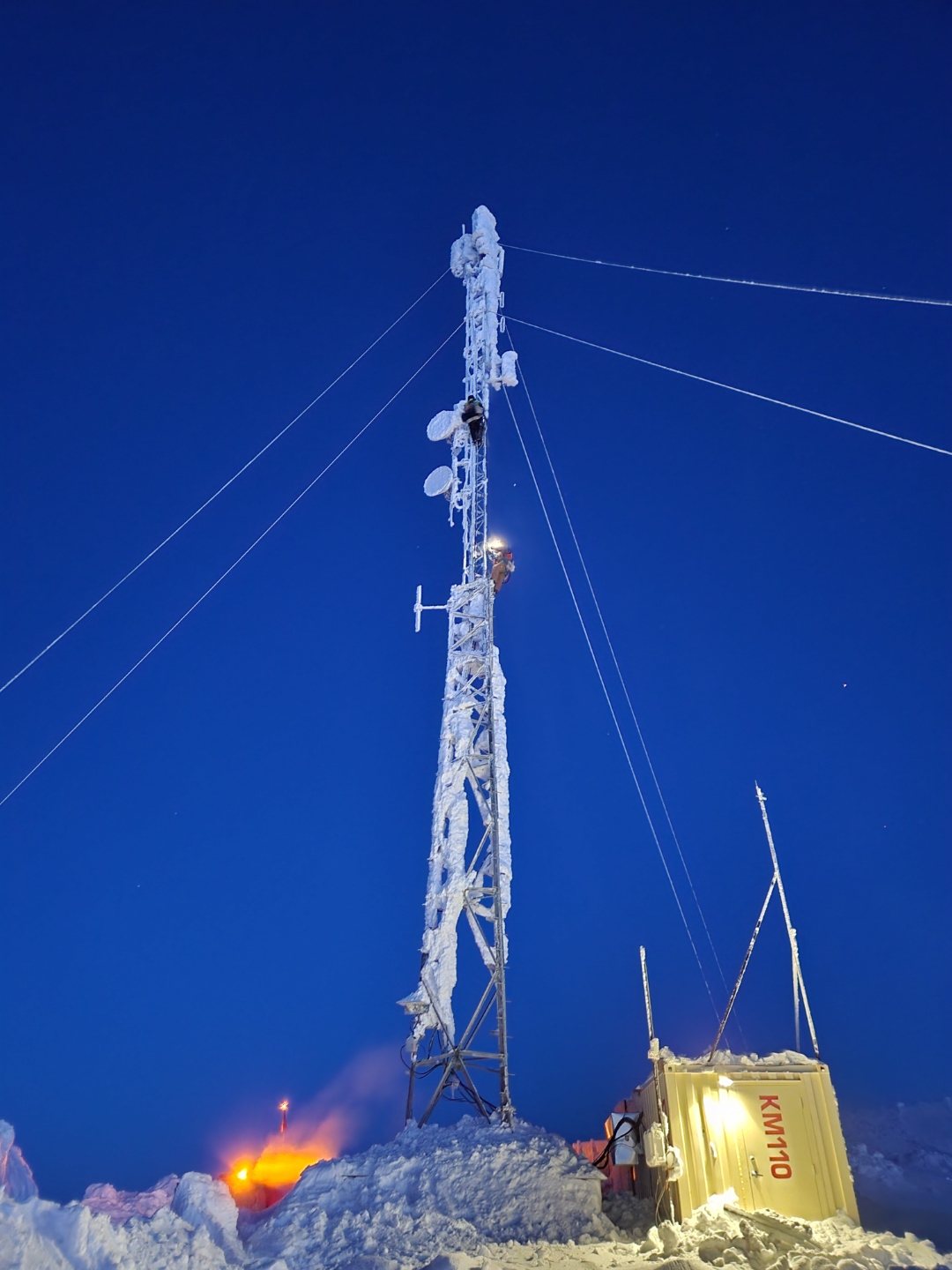 Ice-encrusted lattice tower at dusk, Arctic site